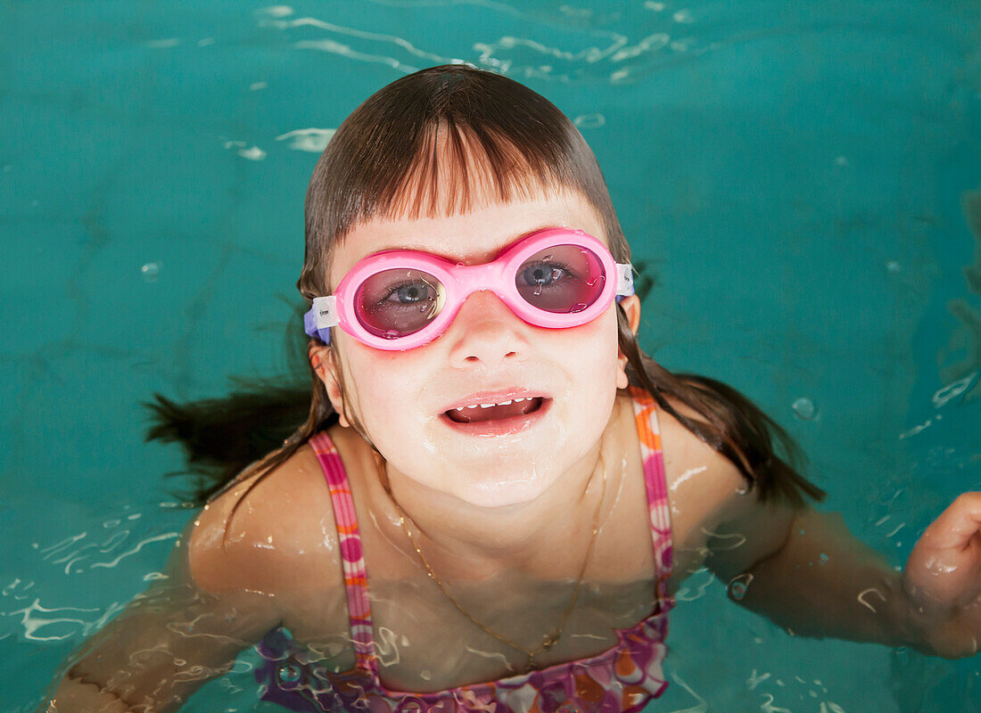 'A young girl wearing pink goggles in a swimming pool;Gold coast queensland australia'