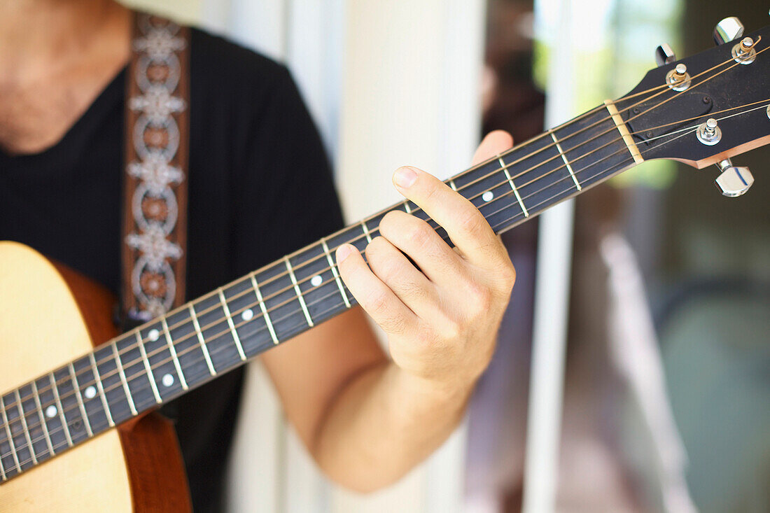 'A man playing his guitar;Wailua kauai hawaii united states of america'