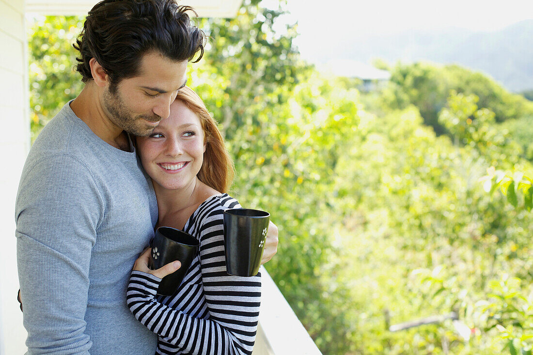 'A couple on a balcony with their coffee mugs;Wailua kauai hawaii united states of america'