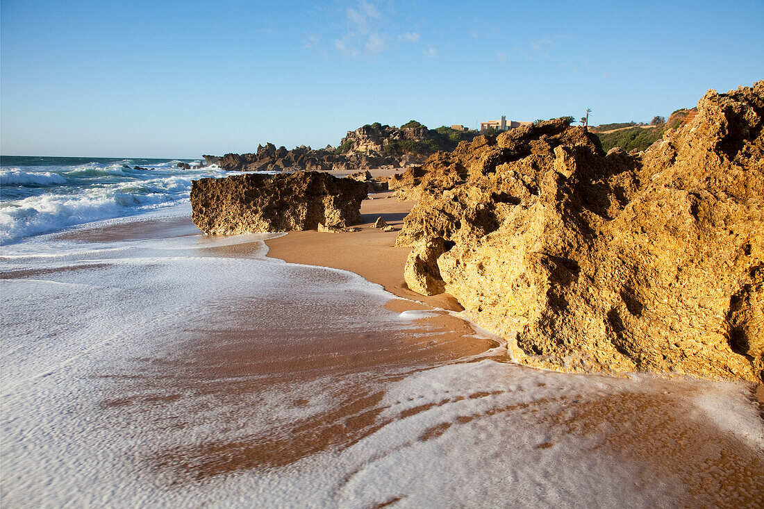'A Rugged Rock Formation Along A Beach Near Chiclana De La Frontera; Andalusia, Spain'