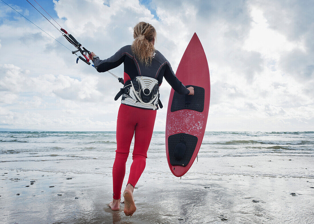 'A Young Woman With Her Equipment For Kite Surfing On Dos Mares Beach; Tarifa, Cadiz, Andalusia, Spain'