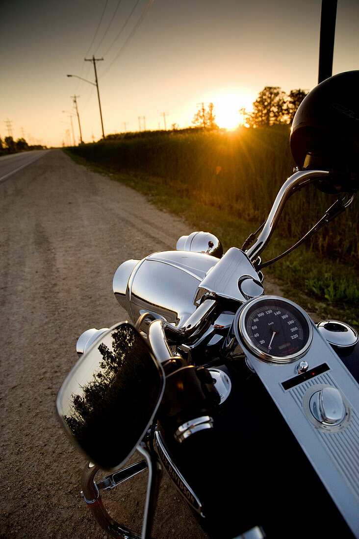 Motorcycle Parked On The Side Of The Road At Sunset