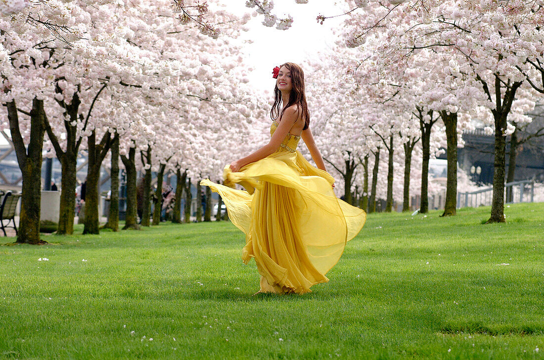 Woman In Yellow Dress Dancing Among Flowering Trees