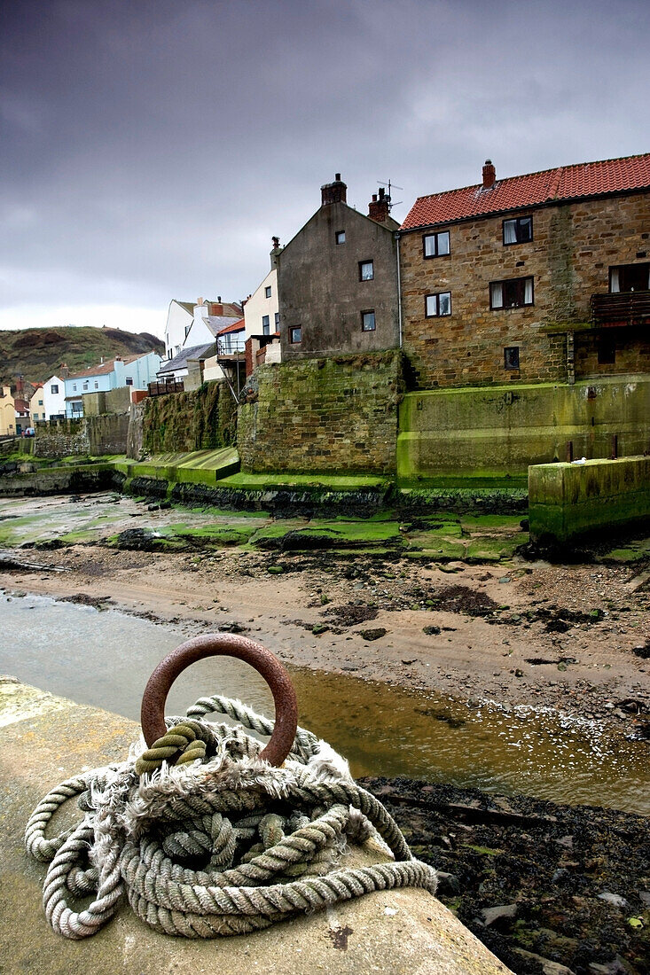 'Staithes, Yorkshire, England; Rope Tied To Pier By Beach'