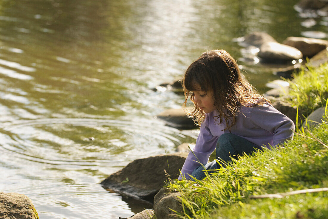 Young Girl Playing By Pond