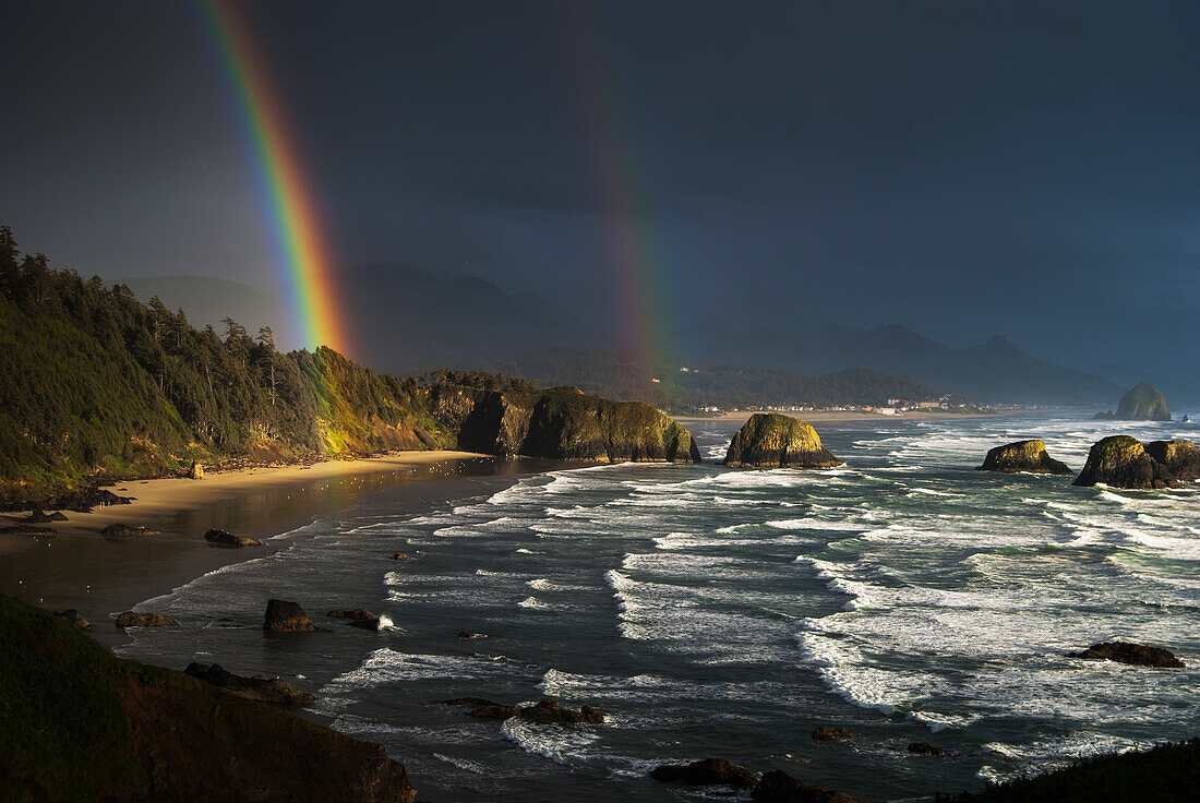 'Rainbows seen through storm clouds over Crescent Beach; Cannon Beach, Oregon, United States of America'