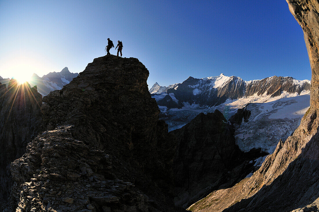 Zwei Bergsteiger während Sonnenaufgang am Ostegg, Eiger (3970 m), Berner Alpen, Schweiz