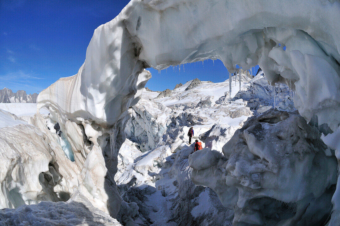 Bergsteiger springen über eine Gletscherspalte, Vallee Blanche, Mont Blanc-Gruppe, Frankreich