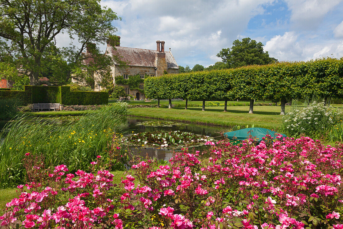 Blick vom Rosengarten über den Seerosenteich zum Herrenhaus, Bateman's, Haus des Schriftstellers Rudyard Kipling, East Sussex, Großbritannien