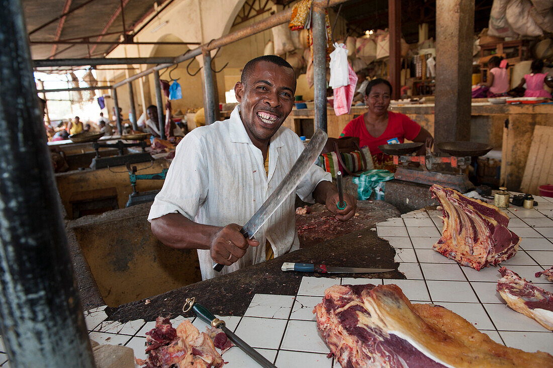 Metzger wetzt sein Messer an einem Marktstand, Nosy Be, Madagaskar