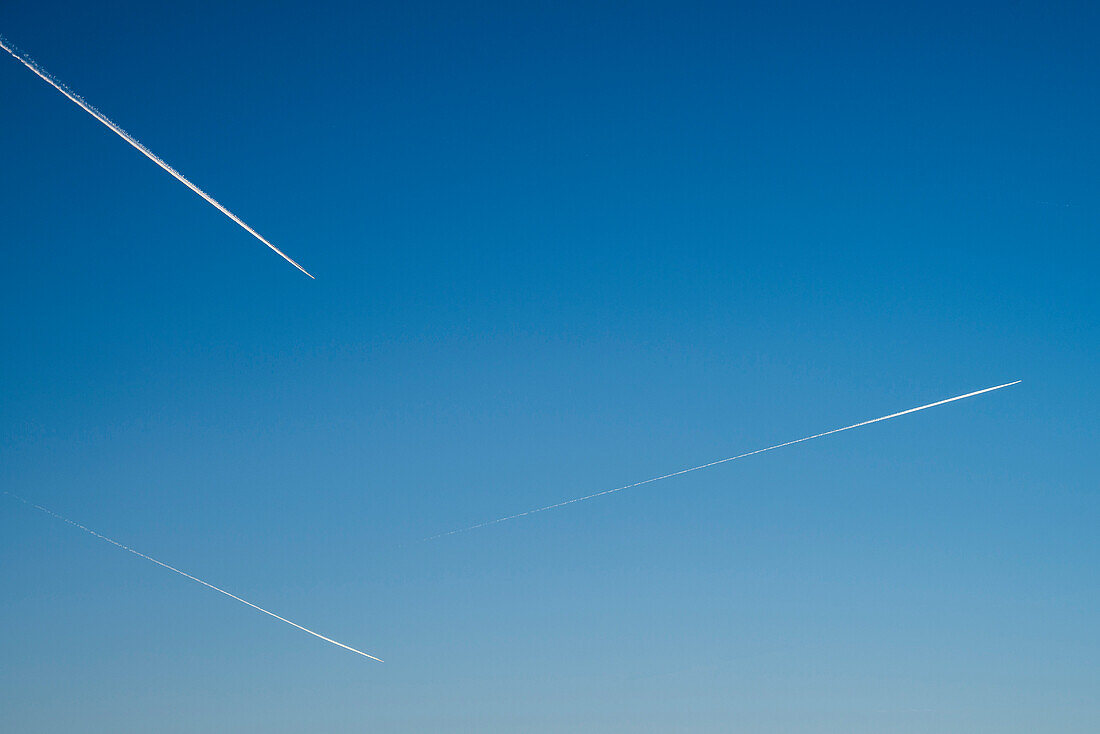 drei Flugzeuge am klaren blauen Himmel hinterlassen Kondensstreifen, München, Bayern, Deutschland