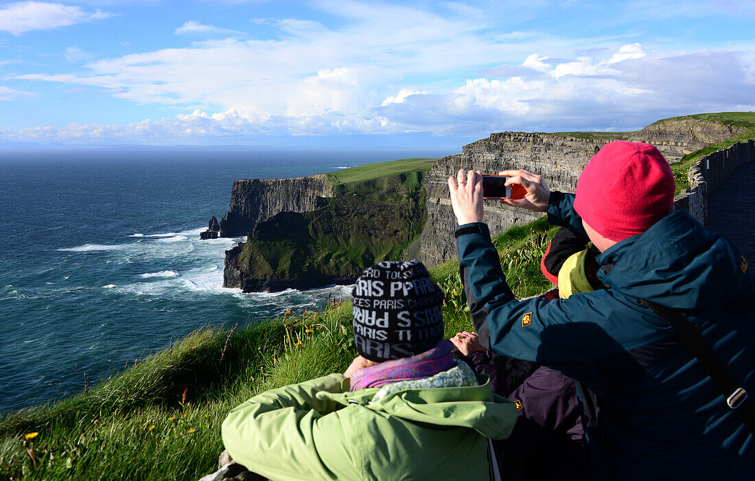 Leute beim Fotografieren an den Cliffs of Moher, Clare, Westküste, Irland