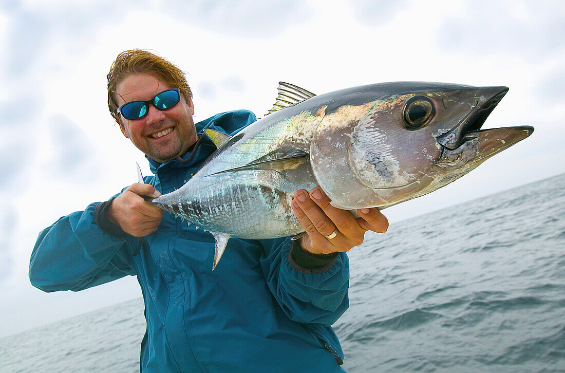 'Man holding fresh caught bluefin tuna; massachusetts united states of america'