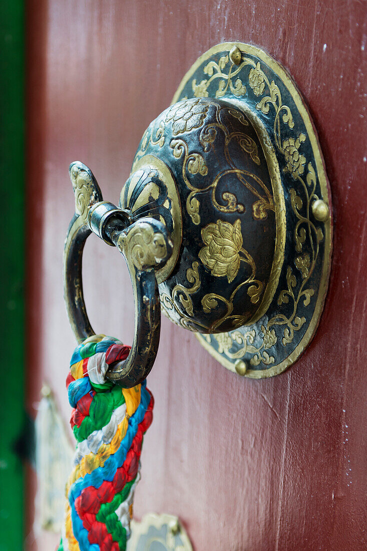 'Ornate doorknob with colourful fabric hanging from the ring;Lhasa xizang china'