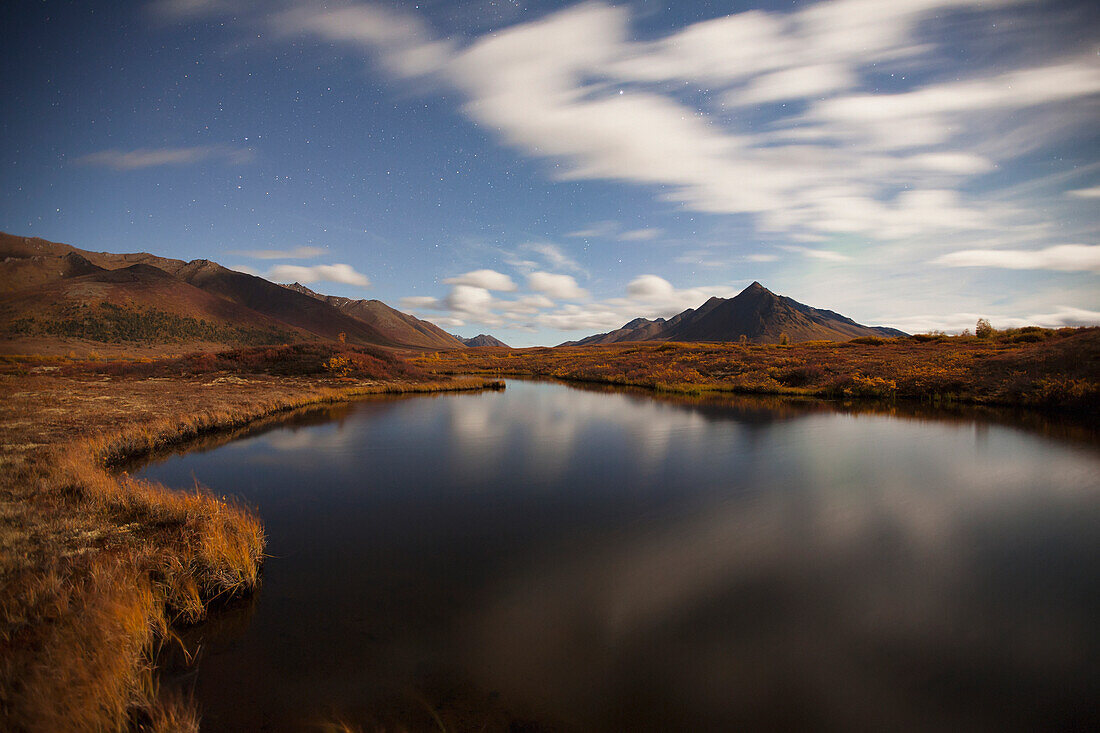 'Clouds reflected in a small pond along the dempster highway and landscape;Yukon canada'