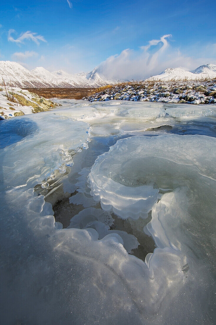 'The ice in a stream leading off into a snow covered valley haines highway;British columbia canada'