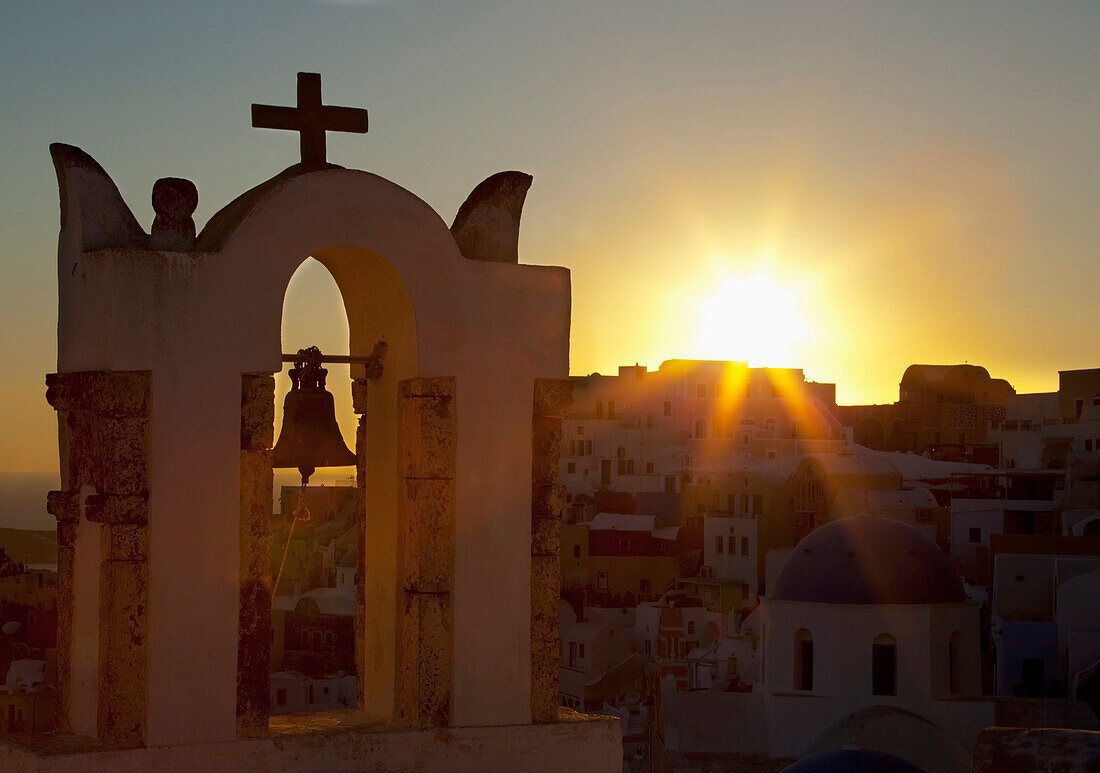 'Cross and bell on a structure at sunset;Oia greece'
