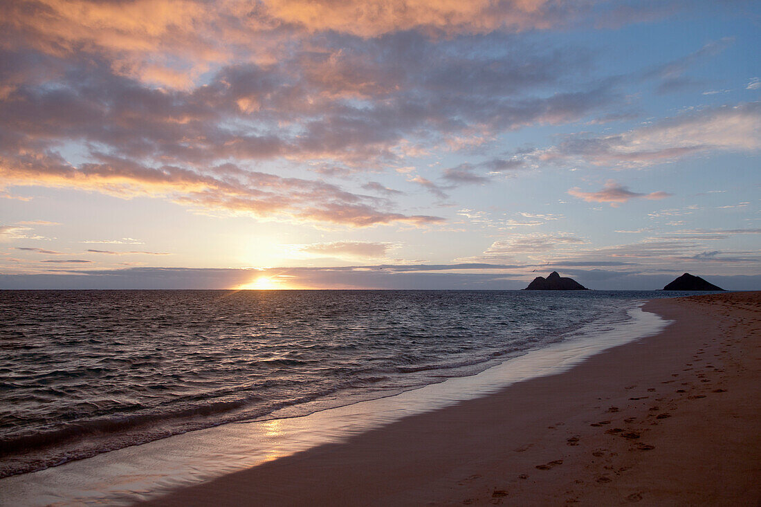 'Footprints in the sand along the water's edge at sunset;Honolulu hawaii united states of america'