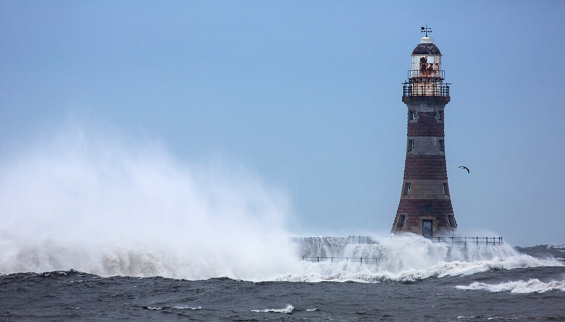 'Splashing water from a crashing wave against a lighthouse;Sunderland Tyne and Wear England'
