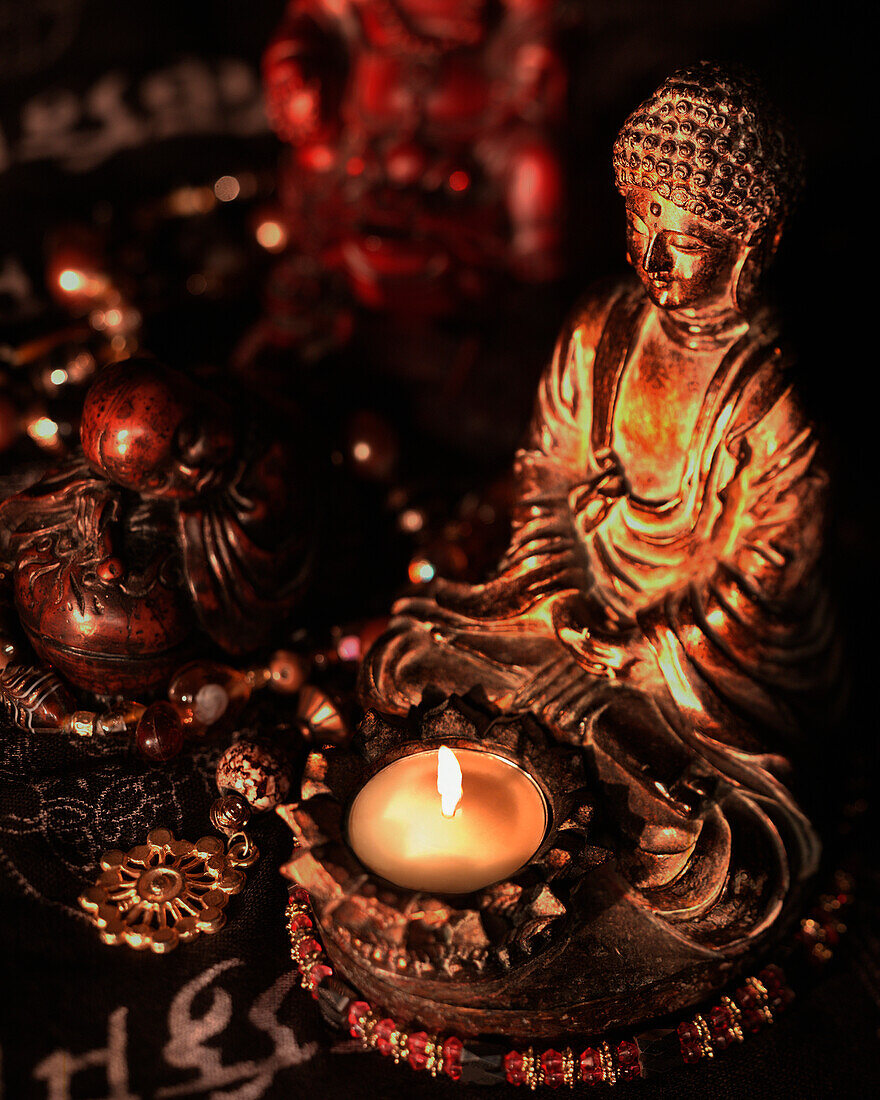 'Statues Of Buddha Illuminated By A Single White Candle In A Dark Environment; California, United States Of America'