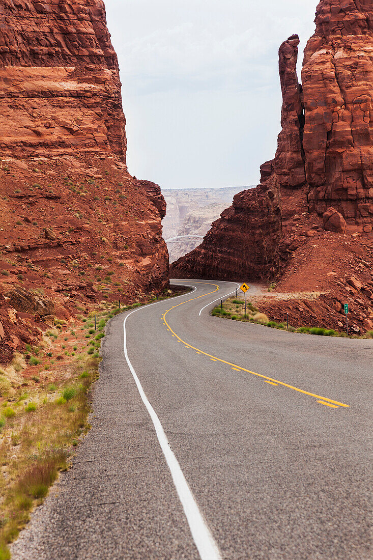 'Highway 95 West Of Hite, Utah As The Road Drops Down Between Two Red Sandstone Formations To The Colorado River; Utah, United States Of America'