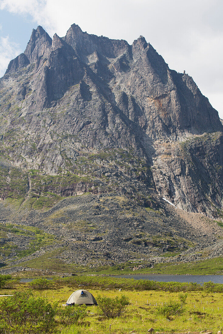 'Tent in meadow near lake with towering mountain in the background; Yukon, Canada'