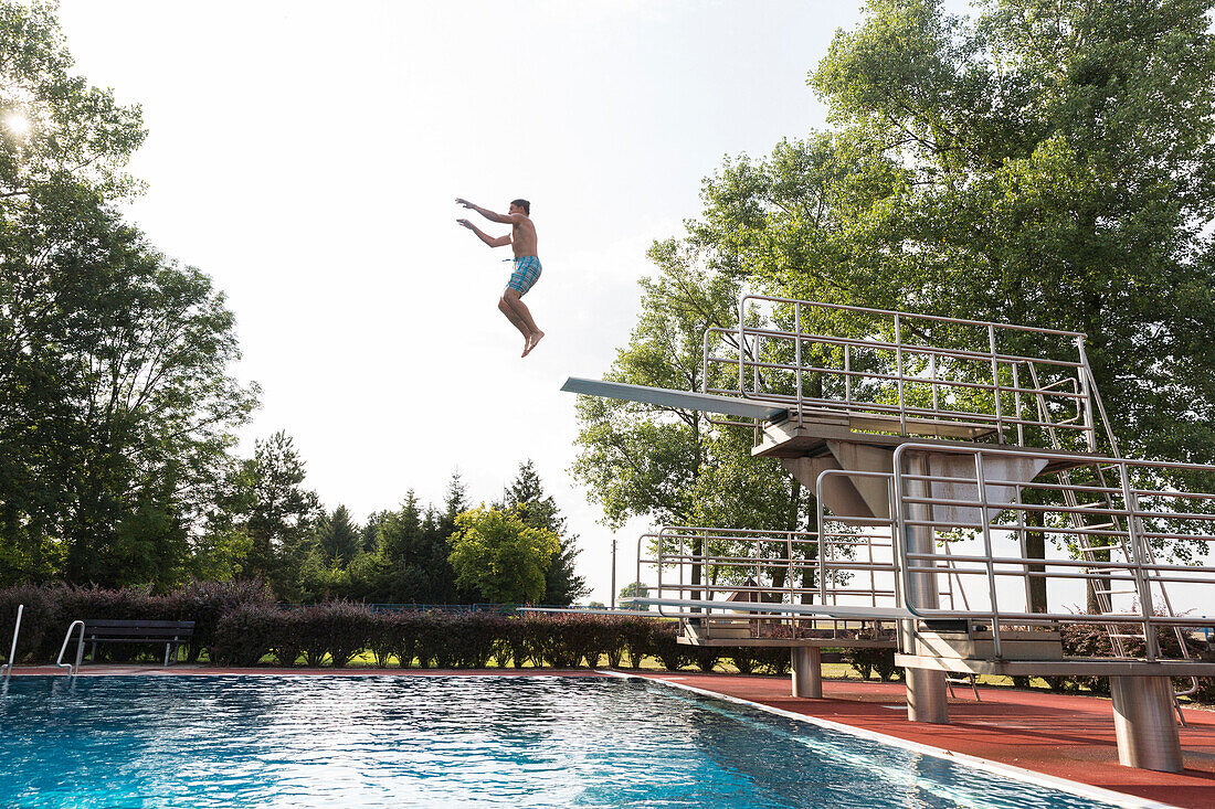 Mann springt vom Sprungturm in einem Schwimmbad, Leipzig, Sachsen, Deutschland
