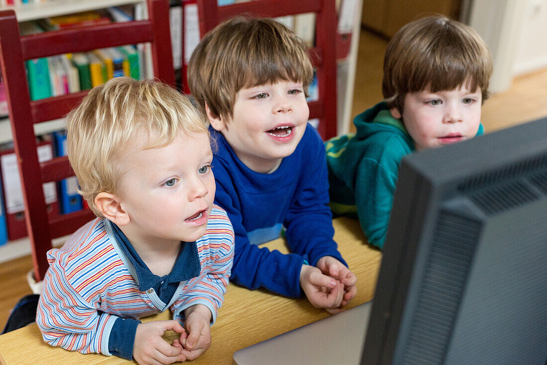 Drei Jungen betrachten Computerbildschirm