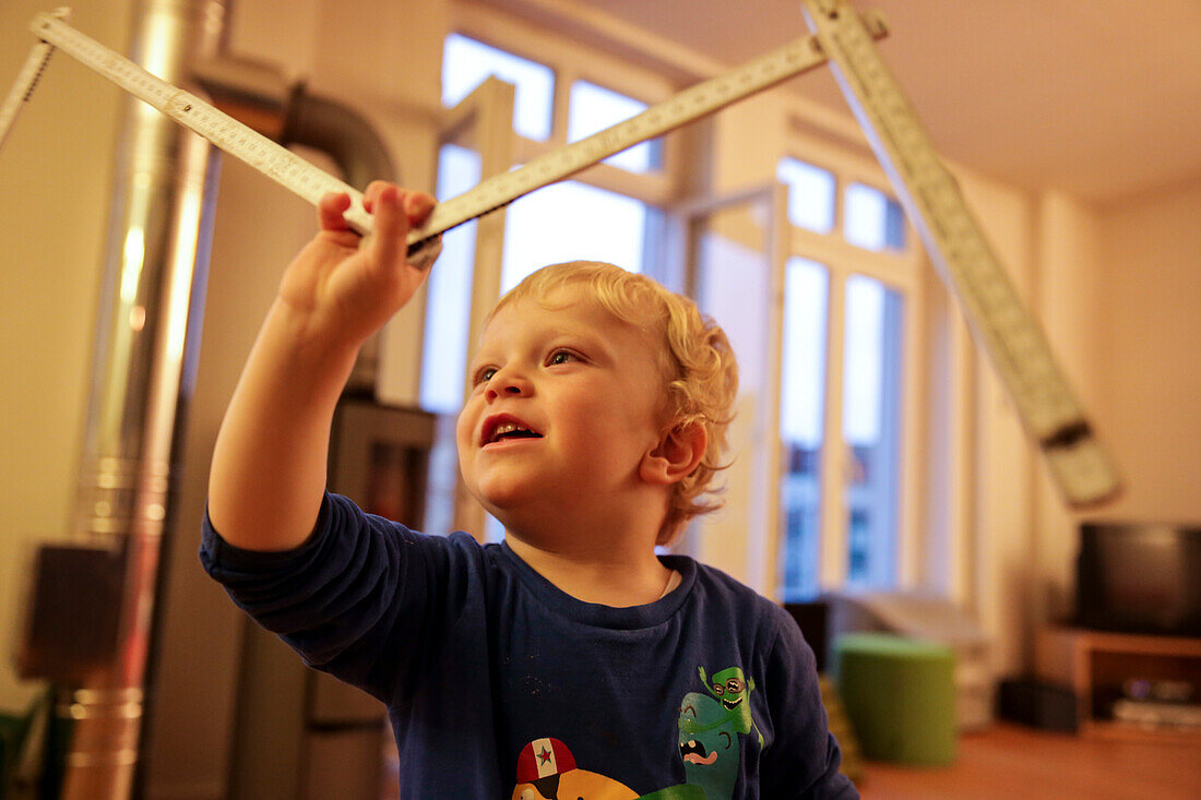 Boy (3 years) holding a folding ruler, Leipzig, Saxony, Germany