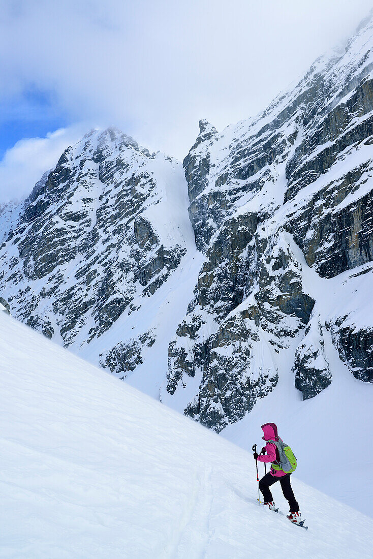 Frau auf Skitour steigt zum Piz Zuort auf, Piz Pisoc im Hintergrund, Piz Zuort, Sesvennagruppe, Engadin, Graubünden, Schweiz