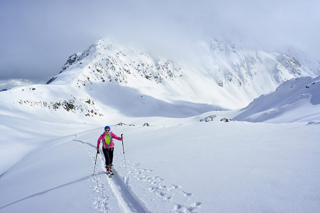 Female ski tourer ascending to Piz Sasuret, Piz Sasuret, Albula Alps, Engadin, Canton of Graubuenden, Switzerland