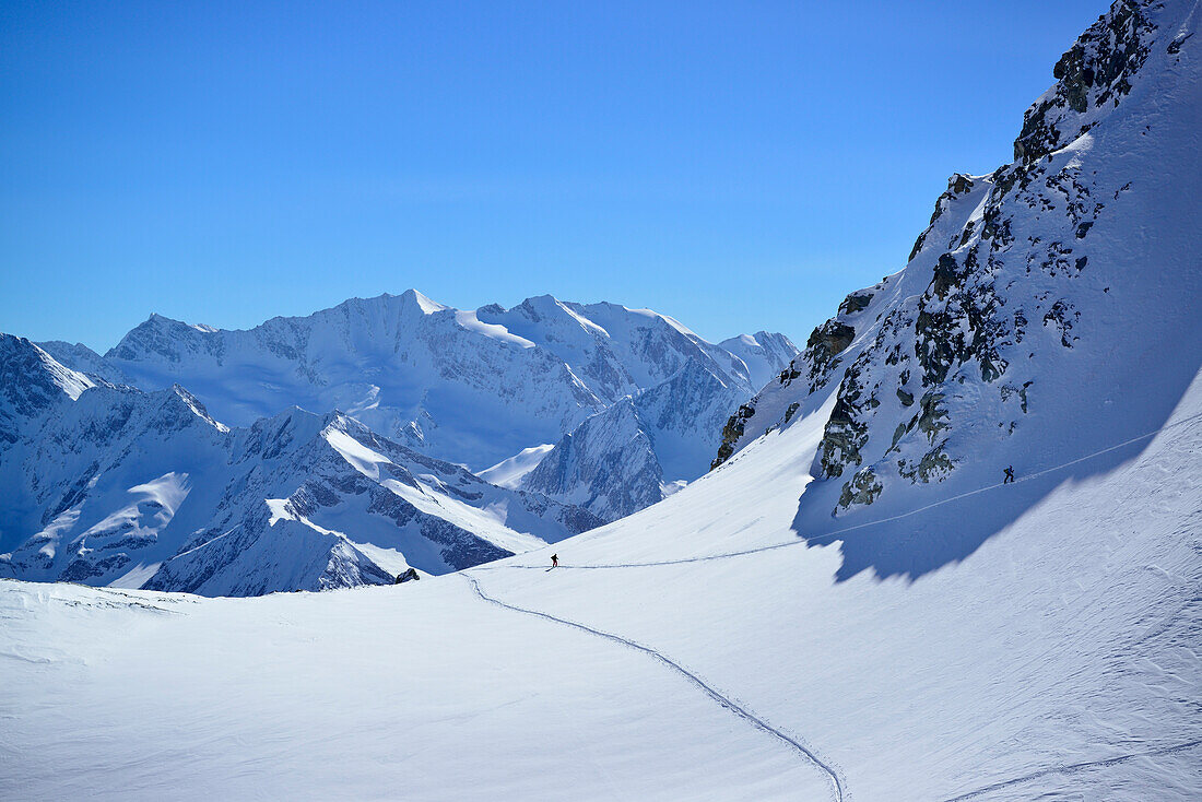 Back-country skier ascending to Realspitze, Hochfeiler and Hochferner in background, Zwerchwand, Zillertal, Zillertal Alps, Tyrol, Austria