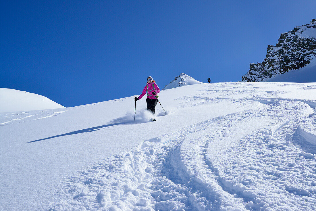 Female back-country skier downhill skiing from Eiskoegele, Obergurgl, Oetztal Alps, Tyrol, Austria