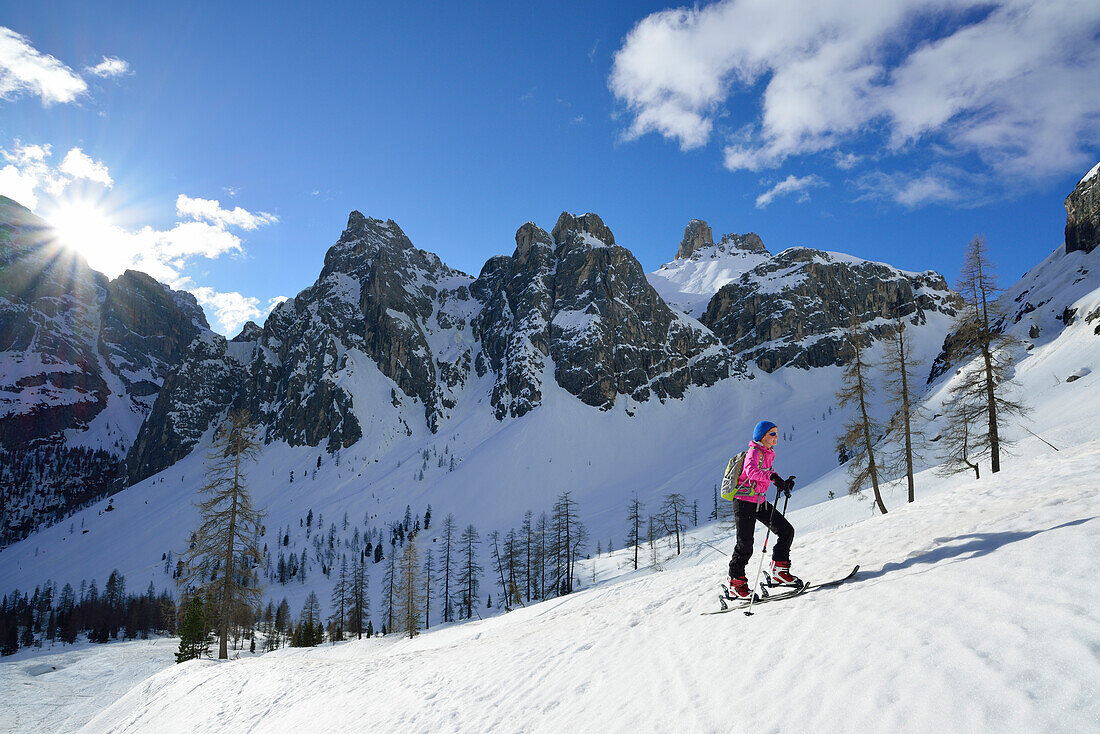 Frau auf Skitour steigt zum Hochebenkofel auf, Paternkofel und Schwabenalpenkopf im Hintergrund, Sextener Dolomiten, Südtirol, Italien