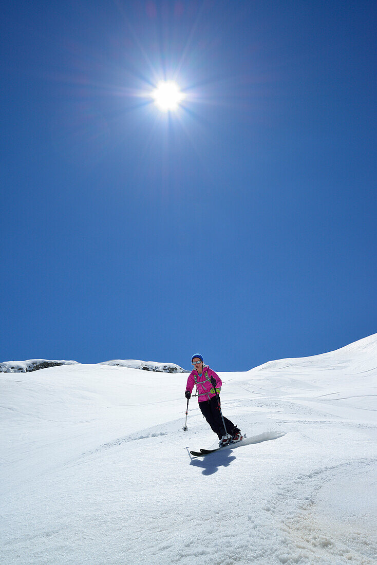 Female back-country skier downhill skiing from Corno d Angolo, Cristallo Group, Dolomites, Veneto, Italy