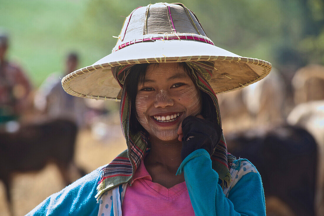 Shan Mädchen mit Hut und Tanaka Paste im Gesicht hütet Rinder, auf dem Weg nach Pindaya, Shan Staat, Myanmar, Burma