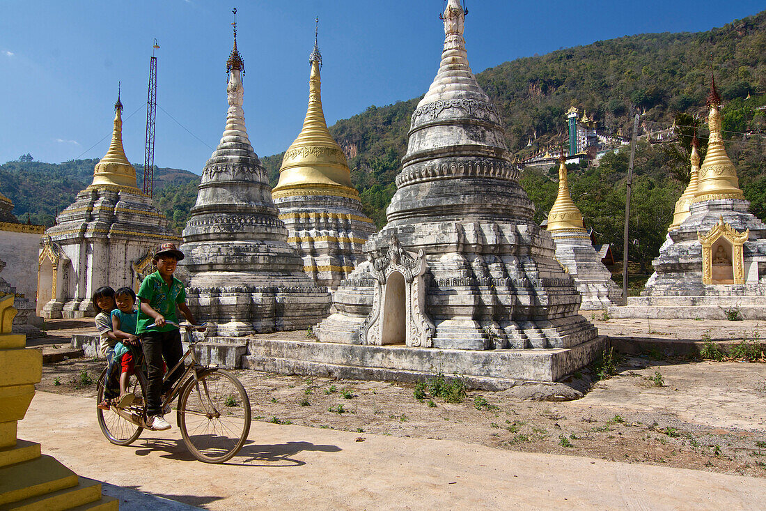 Drei Kinder auf einem Fahrrad in Pindaya, Shan Staat, Myanmar, Burma