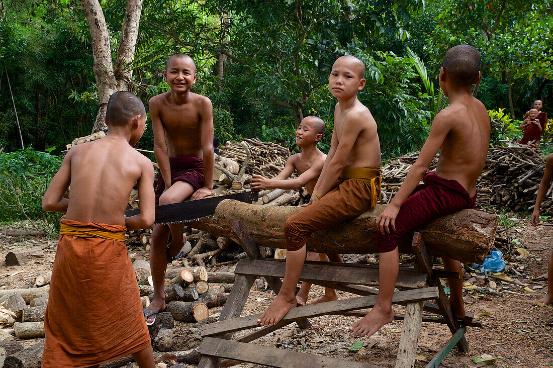 Buddhist novices sawing wood in a monastry in Mawlamyine, Moulmein Capital of Mon State, in the South of Myanmar, Burma