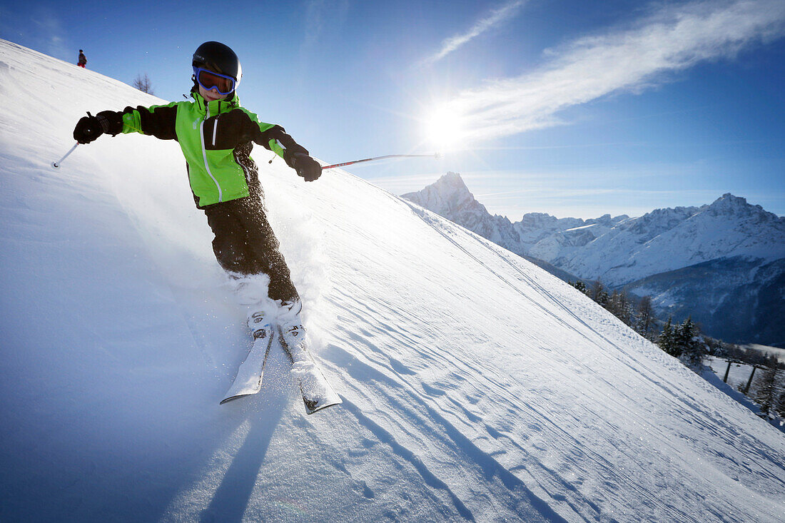Boy downhill skiing from mount Helm (Monte Elmo), Sexten, South Tyrol, Italy
