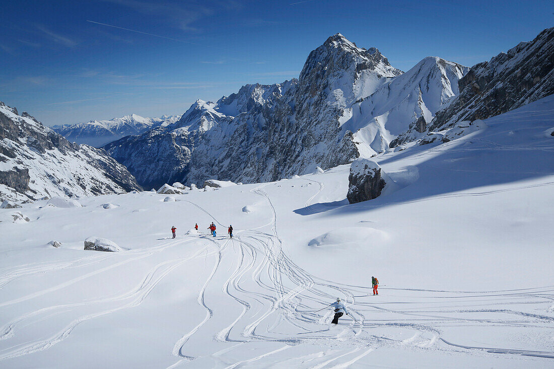 Skiers downhill skiing from mount Zugspitze, Upper Bavaria, Germany