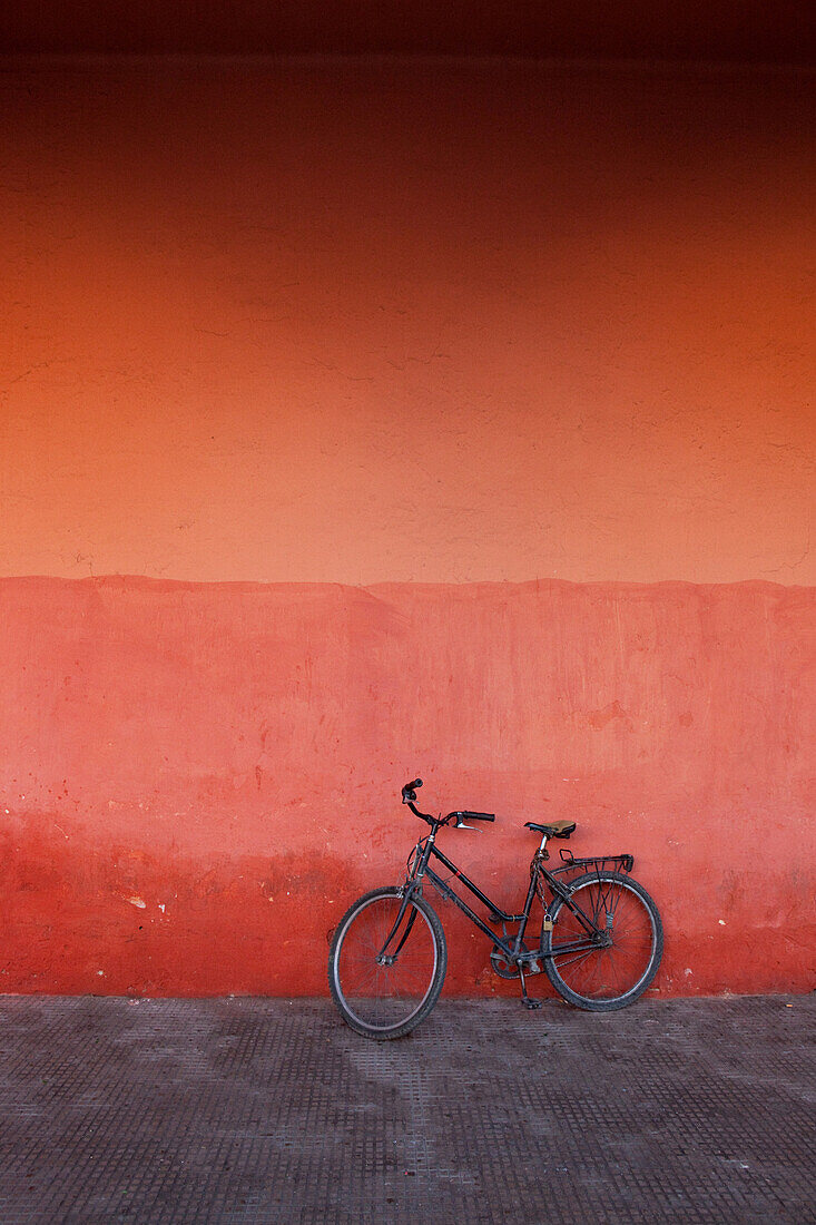Cycle leaning against a red wall, Marrakech, Morocco