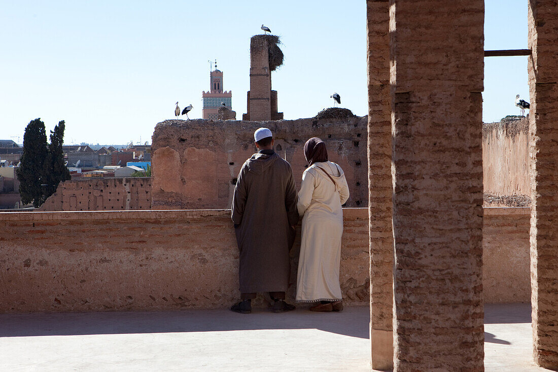 Moroccan couple watching storks at Badi Palace, Saadit graves, Marrakech, Morocco