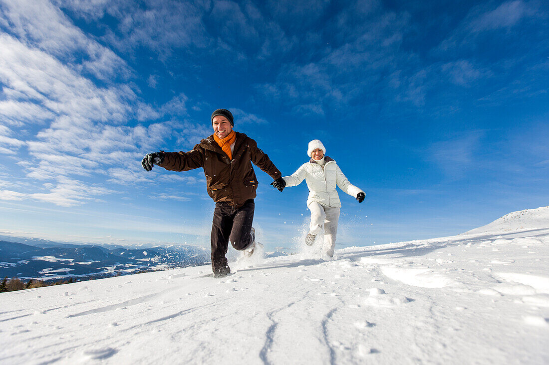 Paar rennt durch Schnee, Zirbitzkogel, Mühlen, Steiermark, Österreich