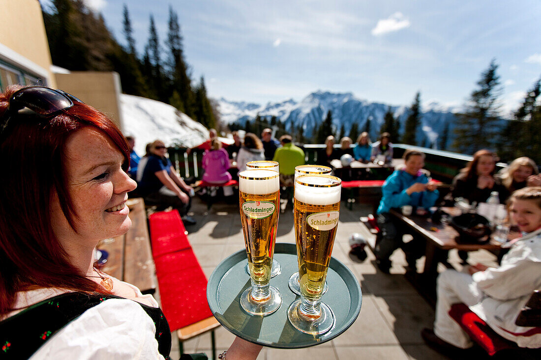 Waitress serving beers at ski hut terrace, Planai, Schladming, Styria, Austria