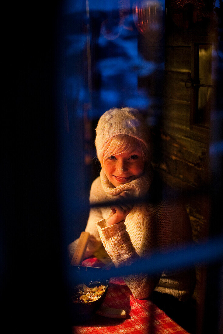 Smiling young woman looking through a window