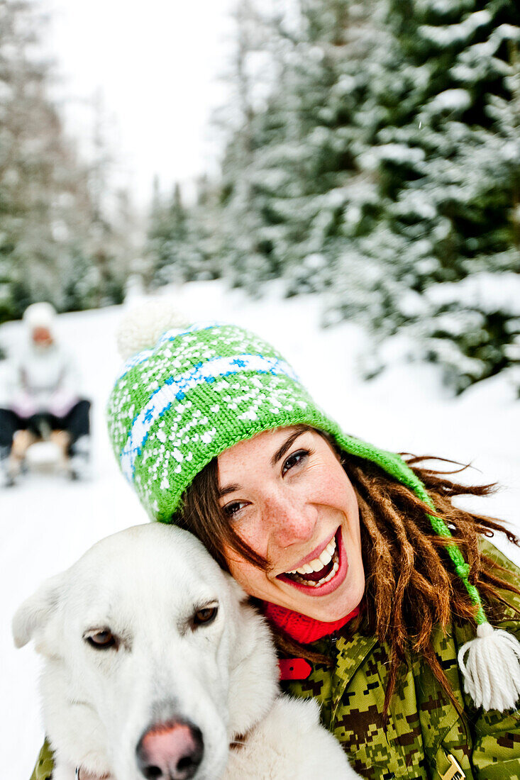 Young woman and a white dog in snow