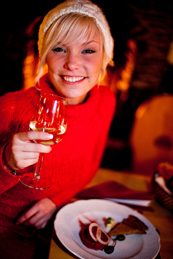 Junge Frau trinkt ein Glas Wein zum Abendessen