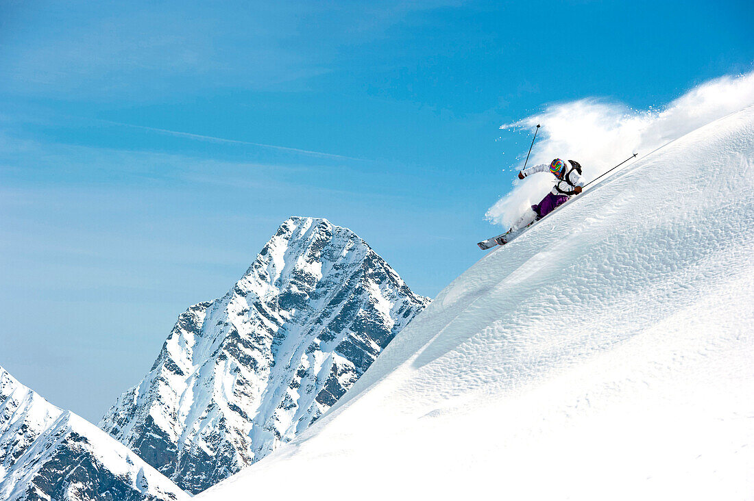 Skier downhill skiing in deep snow, Alagna Valsesia, Piedmont, Italy