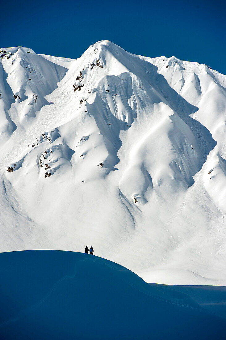 Zwei Personen vor verschneiter Berglandschaft, Gargellen, Montafon, Vorarlberg, Österreich