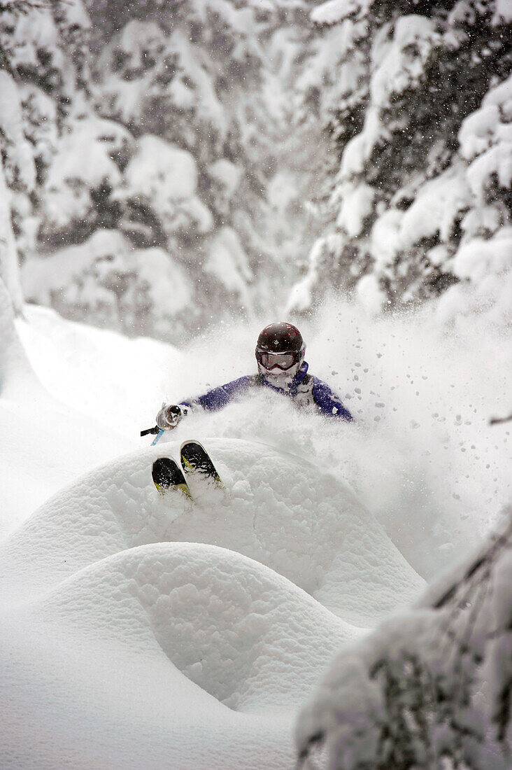 Skier downhill skiing in deep snow, St Anton am Arlberg, Tyrol, Austria